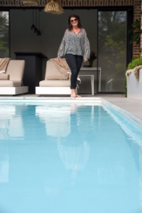 vrouw loopt op terras naast een zwembad in een stadstuin met een ultiem vakantie gevoel