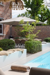 parasol op een terras naast een zwembad in een stadstuin met een ultiem vakantie gevoel