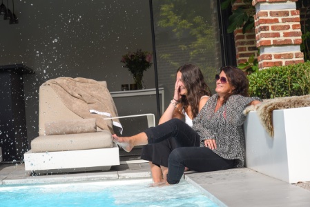Damen genieten van hun staycation naast een zwembad in een stadstuin met een ultiem vakantie gevoel