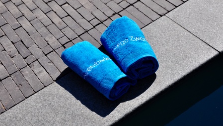 opgerolde handdoeken naast het zwembad