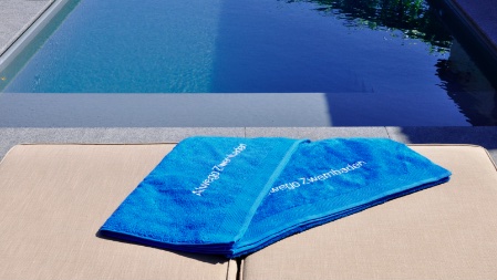 handdoeken liggen naast het zwembad