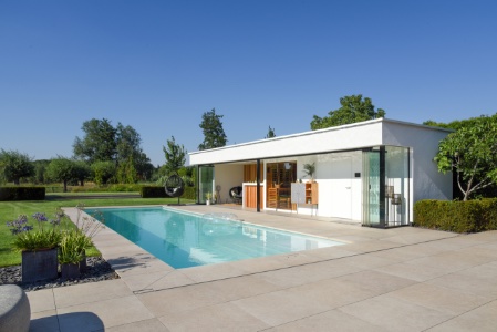 poolhouse naast wit zwembad met maatwerk hoektrap