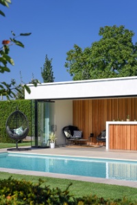 poolhouse naast wit zwembad met maatwerk hoektrap