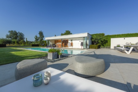 poolhouse naast wit zwembad met maatwerk hoektrap