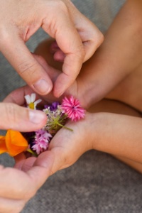 moeder en dochter plukken bloemen naast een wit zwembad met maatwerk hoektrap