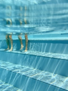 onderwaterfoto goor benen op de trappen van een zwembad