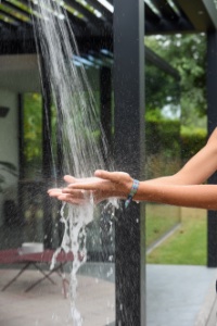 handen afspoelen onder de buitendouche in een tuin met een zwembad met Unicus-poolhouse