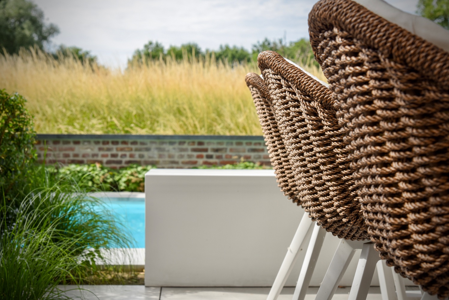 terrasstoelen naast een zwembad in een stadstuin met een ultiem vakantie gevoel