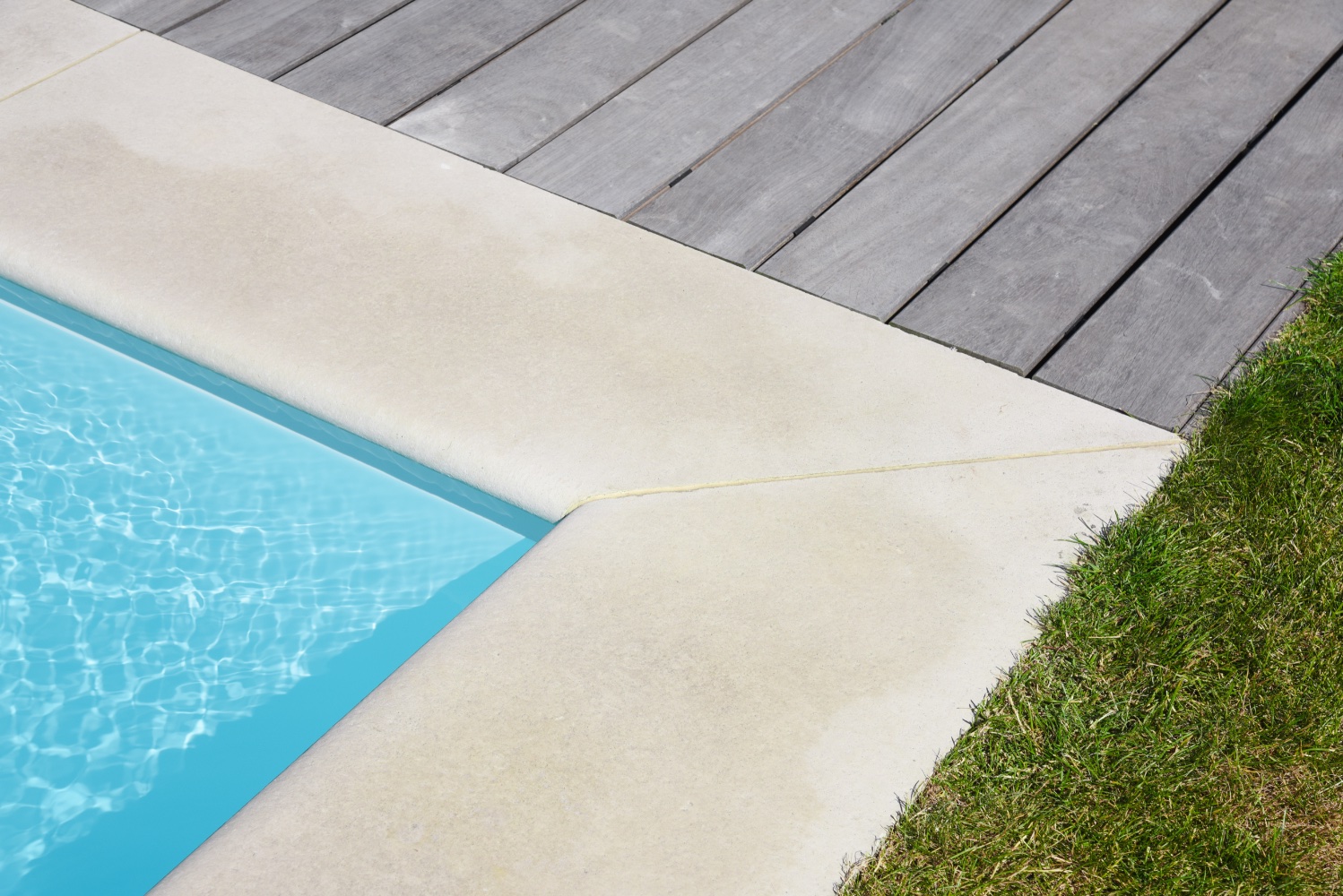 rand van een strak wit zwembad bij moderne villa
