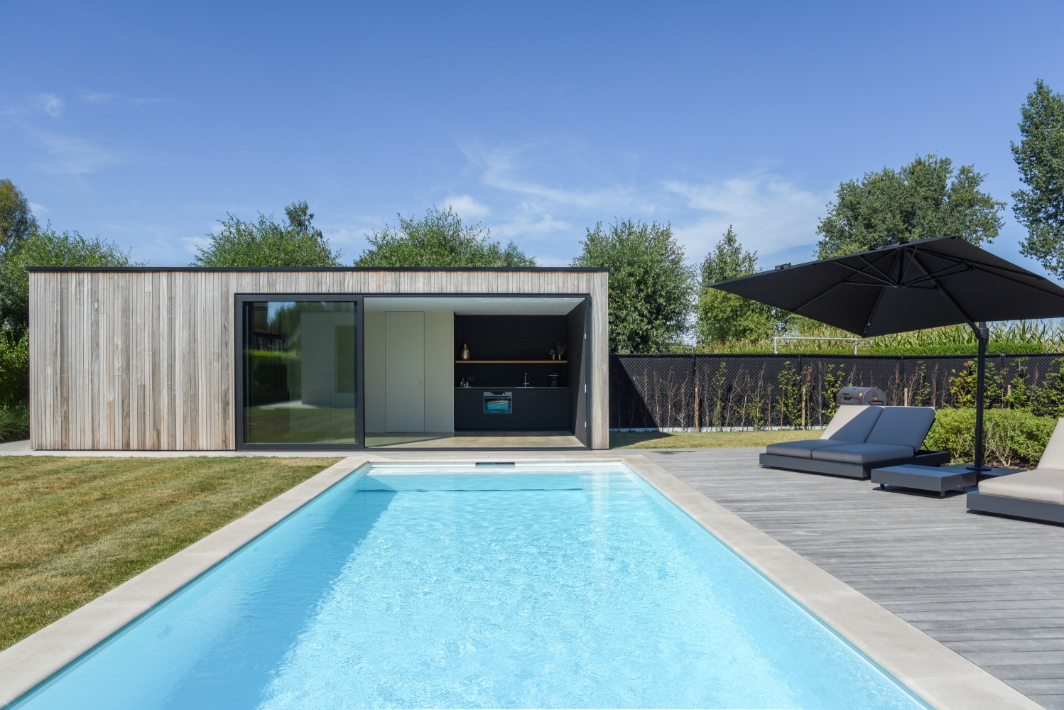 strak wit zwembad bij moderne villa met poolhouse