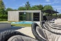 terras en poolhouse naast een strak wit zwembad bij moderne villa