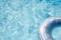 zwemband drijft op het water van een strak wit zwembad bij moderne villa
