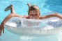 kind in zwemband in een strak wit zwembad bij moderne villa