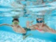 onderwater foto goor van kindjes in strak wit zwembad bij moderne villa