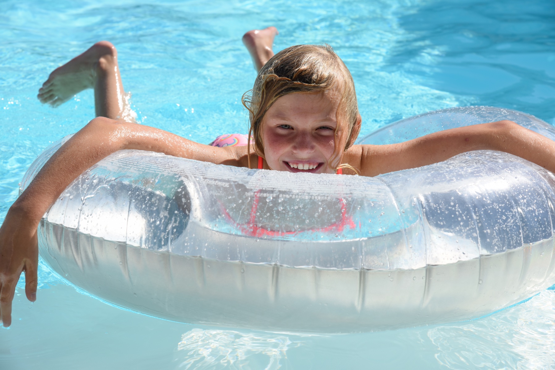 waterpret is eigen zwembad dochter geniet in een zwemband op het water van hun prive biopool