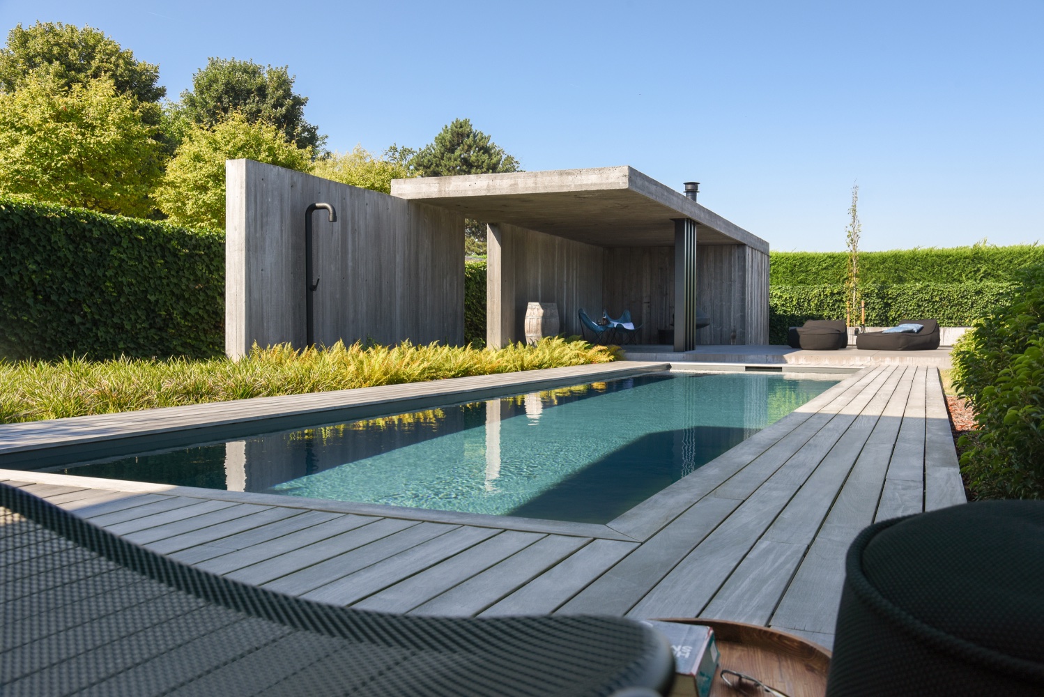 strak tuinontwerp met poolhouse uit beton en prachtig strak design zwembad