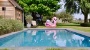 roze flamingo naast een lichtgrijs zwembad met rolluikplage en trap